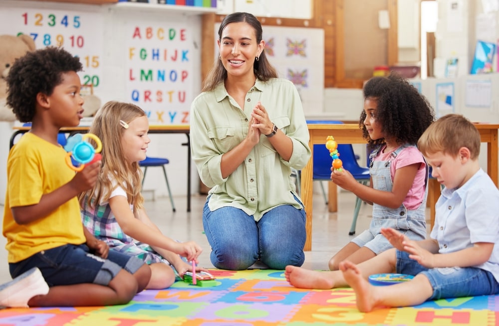 A teacher singing and playing with a group of preschool children at A Step Above Day Care Academy.